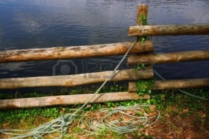 4643104-rustic-wooden-fence-with-ropes-near-a-river-shore